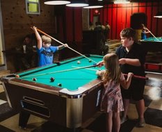 Kids playing pool in the back room